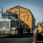 Ein amerikanischer LKW transportiert ein Haus auf dem Highway